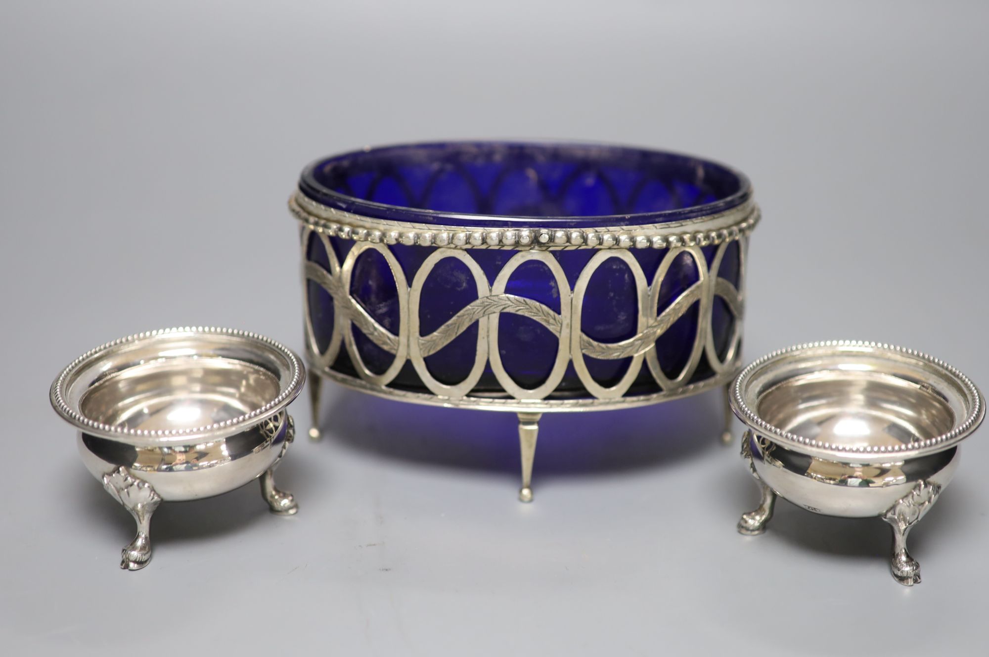 An 18th/19th century Continental silver beaded openwork oval table salt cellar with blue glass liner and a pair of cauldron salts